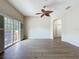 Inviting living area with wood-look floors, ceiling fan, and sliding doors to an outdoor balcony at 3311 Pine Oak Trl, Sanford, FL 32773