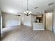 Open-concept living room and kitchen with modern chandelier, breakfast bar, and wood-look flooring at 3311 Pine Oak Trl, Sanford, FL 32773