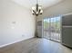 Light-filled living room with wood-look floors, modern chandelier, and access to a balcony at 3311 Pine Oak Trl, Sanford, FL 32773