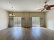 Spacious living area with wood-look floors, access to a balcony, and contemporary lighting at 3311 Pine Oak Trl, Sanford, FL 32773