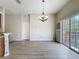 Bright living room with wood-look floors, chandelier, and sliding glass doors to a balcony at 3311 Pine Oak Trl, Sanford, FL 32773
