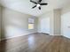 This main bedroom has a ceiling fan, wood-look floors and double closet with sliding doors at 3311 Pine Oak Trl, Sanford, FL 32773