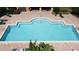 Aerial view of a well-maintained community pool with ample lounge chairs and beautiful brick paver deck at 3311 Pine Oak Trl, Sanford, FL 32773