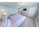 Bedroom with bright blue walls and striped bedding and a partial kitchen view at 3311 S Atlantic Ave # 801, Daytona Beach, FL 32118