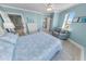 A coastal bedroom with blue bedding, a sitting area, and bathroom access at 3311 S Atlantic Ave # 801, Daytona Beach, FL 32118