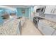 Bright kitchen with white cabinetry, stainless steel appliances, and an island with speckled granite countertop at 3311 S Atlantic Ave # 801, Daytona Beach, FL 32118