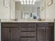 Bathroom featuring double sinks, granite countertop, and dark wood cabinets with bronze hardware at 3376 Leonardo Ln, New Smyrna Beach, FL 32168
