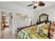Bright bedroom features tropical bedding, decorative mirror, and ceiling fan at 3376 Leonardo Ln, New Smyrna Beach, FL 32168