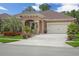 Charming home exterior featuring a well-maintained lawn, lovely landscaping, and a convenient two-car garage at 3376 Leonardo Ln, New Smyrna Beach, FL 32168