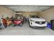A well-organized two-car garage featuring a golf cart, workspace, and ample storage space at 3376 Leonardo Ln, New Smyrna Beach, FL 32168