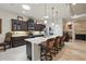 Open kitchen layout with a large island, dark cabinets, stainless steel appliances and a cozy fireplace at 3376 Leonardo Ln, New Smyrna Beach, FL 32168