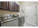 Laundry room featuring a modern washer and dryer, dark cabinets, and granite countertop at 3376 Leonardo Ln, New Smyrna Beach, FL 32168