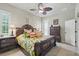 Elegant main bedroom featuring a decorative ceiling fan, tropical bedding, and dark wood furniture at 3376 Leonardo Ln, New Smyrna Beach, FL 32168