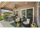 Covered patio with seating area, ceiling fan, and a view of the landscaped backyard at 3376 Leonardo Ln, New Smyrna Beach, FL 32168
