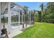 A screened-in pool area with patio furniture, potted plants, and an adjacent grassy yard at 3376 Leonardo Ln, New Smyrna Beach, FL 32168