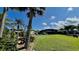 Expansive backyard with lush green grass, mature trees, and a screened-in lanai, perfect for outdoor living at 34 Richmond Dr, New Smyrna Beach, FL 32169