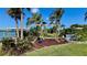 Backyard with landscaping and mature palm trees, offering shaded relaxation and an island lifestyle at 34 Richmond Dr, New Smyrna Beach, FL 32169