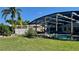 Beautiful backyard featuring an enclosed pool, well-manicured lawn and mature trees at 34 Richmond Dr, New Smyrna Beach, FL 32169