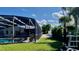 Spacious backyard with an enclosed pool, brick-paver walkway, and mature landscaping at 34 Richmond Dr, New Smyrna Beach, FL 32169