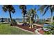 Charming backyard featuring a swing set, tropical landscaping, and a water view at 34 Richmond Dr, New Smyrna Beach, FL 32169