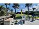 Backyard retreat with outdoor seating, sunny lawn, and lush palm trees providing a perfect space for relaxation at 34 Richmond Dr, New Smyrna Beach, FL 32169