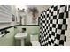 Bright bathroom with black and green tiling, vintage-style fixtures, and decorative accents at 34 Richmond Dr, New Smyrna Beach, FL 32169