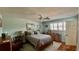Comfortable bedroom with a ceiling fan, wood floors, shuttered window, and decor at 34 Richmond Dr, New Smyrna Beach, FL 32169