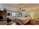 Cozy bedroom featuring a ceiling fan, wood floors, and a large window with natural light at 34 Richmond Dr, New Smyrna Beach, FL 32169