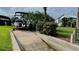 Featuring a concrete boat ramp with lush landscaping and a partial view of a house at 34 Richmond Dr, New Smyrna Beach, FL 32169