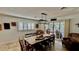 Bright dining area featuring a long wood table set, plantation shutters, and decor art at 34 Richmond Dr, New Smyrna Beach, FL 32169