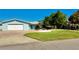 Charming single-story home with a well-manicured lawn, mature trees, and a welcoming facade at 34 Richmond Dr, New Smyrna Beach, FL 32169