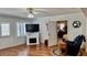 Spacious living room with wood floors, shutters, fireplace and a comfortable chair and ottoman at 34 Richmond Dr, New Smyrna Beach, FL 32169