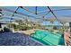 Screened-in pool and spa with brick-paver decking with waterfront views and outdoor dining at 34 Richmond Dr, New Smyrna Beach, FL 32169