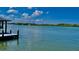 Beautiful water view with a dock, calm waters, and boats on a sunny day with blue skies and clouds at 34 Richmond Dr, New Smyrna Beach, FL 32169