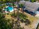 Aerial view showcasing backyard pool, patio, and lush landscaping surrounding the charming blue home at 35 Knollwood Estates Dr, Ormond Beach, FL 32174
