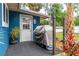 Back porch featuring door, grill, patio and tropical landscaping, perfect for outdoor relaxation and entertaining at 35 Knollwood Estates Dr, Ormond Beach, FL 32174