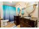 Bathroom with double vanity, dark wood cabinets, granite counters, and a blue shower curtain at 35 Knollwood Estates Dr, Ormond Beach, FL 32174