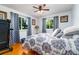 Comfortable bedroom with hardwood floors, a ceiling fan, and two windows with grey curtains at 35 Knollwood Estates Dr, Ormond Beach, FL 32174