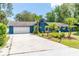 Beautiful blue house features a well-maintained lawn, palm trees, and a spacious driveway at 35 Knollwood Estates Dr, Ormond Beach, FL 32174