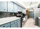 A charming kitchen with light blue cabinets, stainless steel appliances, and attractive tile backsplash at 35 Knollwood Estates Dr, Ormond Beach, FL 32174