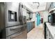 Stainless steel refrigerator in a kitchen with light blue cabinets and views to adjacent rooms at 35 Knollwood Estates Dr, Ormond Beach, FL 32174