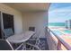 Balcony view of pool and beach with table and chairs at 4151 S Atlantic Ave # 414, New Smyrna Beach, FL 32169