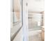 Bright bathroom featuring a bathtub with sliding glass doors and light gray tiles at 4151 S Atlantic Ave # 414, New Smyrna Beach, FL 32169