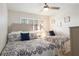 Bright bedroom featuring two beds with patterned comforters, a ceiling fan, and a sunny window at 4151 S Atlantic Ave # 414, New Smyrna Beach, FL 32169