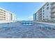 View of the pool area surrounded by lush landscaping and modern condominium buildings at 4151 S Atlantic Ave # 414, New Smyrna Beach, FL 32169