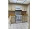 Well-lit kitchen featuring white appliances, tile flooring, and cream-colored cabinetry at 4175 S Atlantic Ave # 5280, New Smyrna Beach, FL 32169