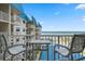 Stunning balcony view of ocean, beachfront, and community pool, complete with comfortable seating, perfect for relaxation at 4201 S Atlantic Ave # 402, New Smyrna Beach, FL 32169