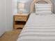 Cozy bedroom with charming wicker headboard, striped bedding, and a functional bedside table, offering comfort at 4201 S Atlantic Ave # 402, New Smyrna Beach, FL 32169