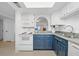 Bright kitchen features white appliances, blue cabinets, and an open view to living area at 4201 S Atlantic Ave # 402, New Smyrna Beach, FL 32169