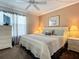 Warm bedroom featuring a plush bed, soft lighting, and a dresser with a TV at 4225 S Atlantic Ave # 218, New Smyrna Beach, FL 32169